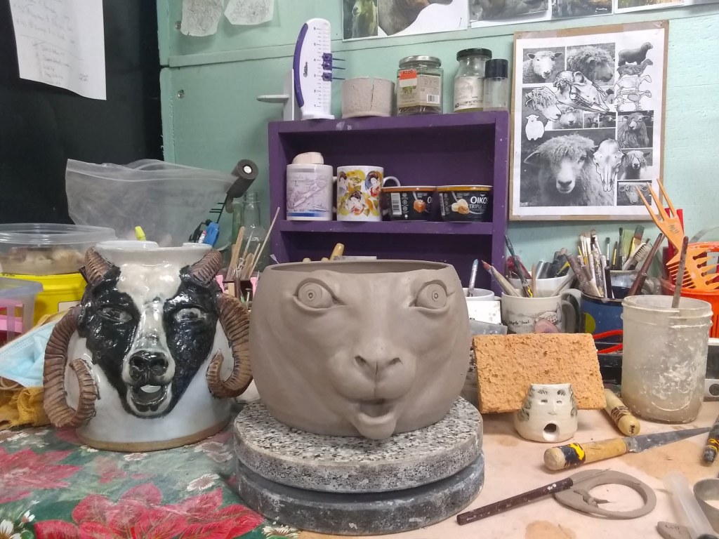 In the studio sculpting heritage breed sheep faces on yarn bowls